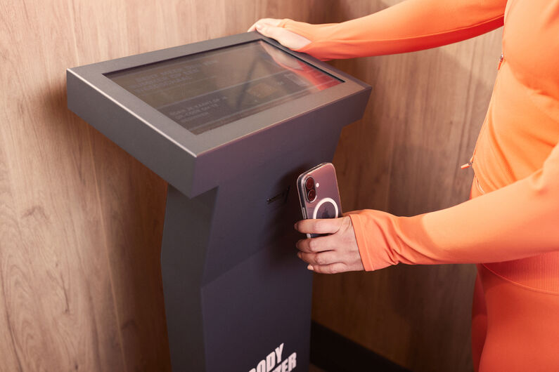 Un membre scanne le QR code du Body Analyzer Basic-Fit avec l'application Basic-Fit pour d&eacute;marrer une analyse de la composition corporelle.