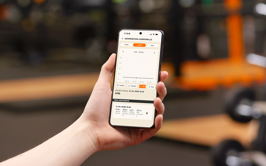 Membre consultant sa masse osseuse et son analyse de composition corporelle dans l'application Basic-Fit pendant sa s&eacute;ance de sport.