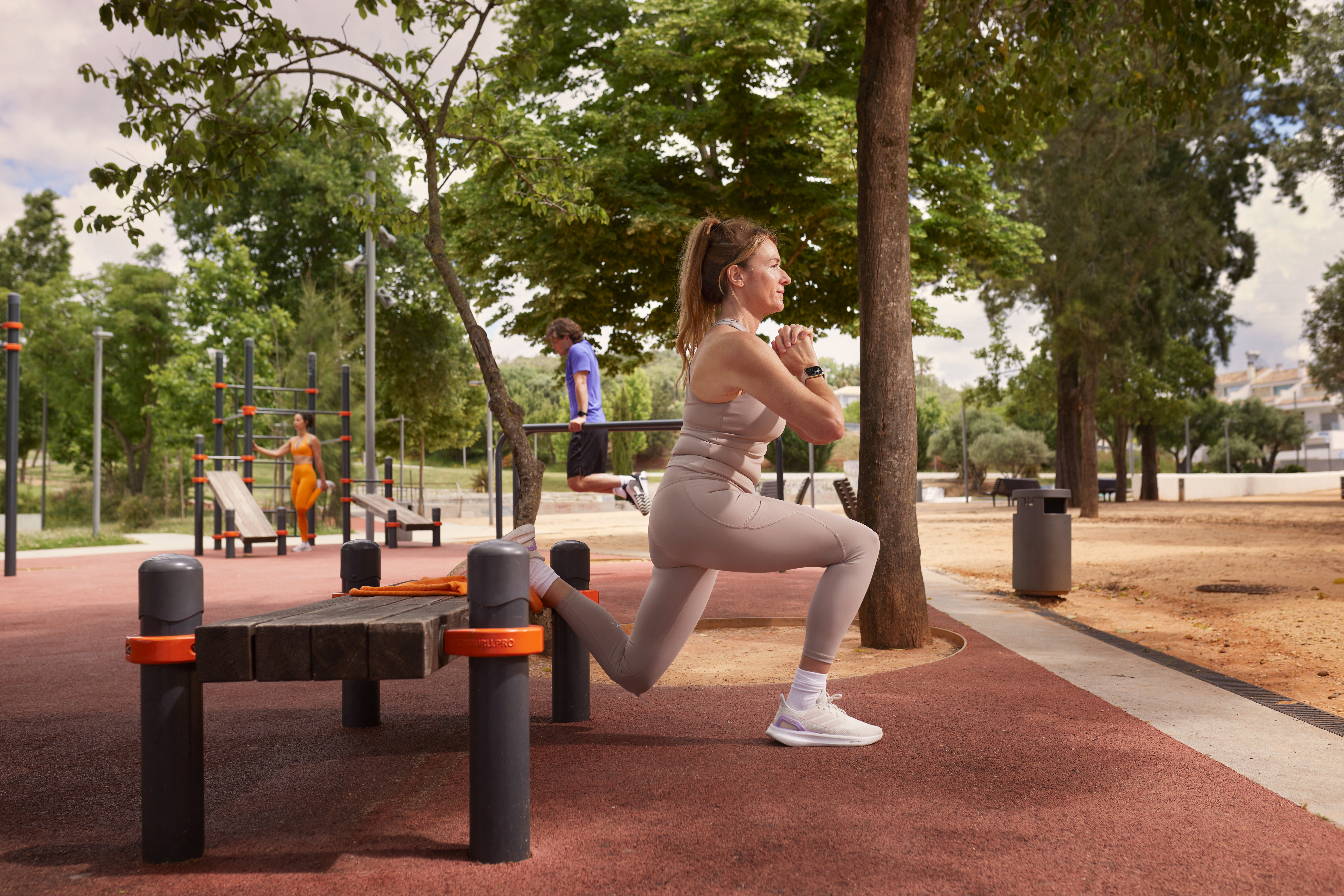 Une femme fait des fentes dans un parc de fitness