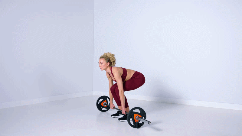 Girl performing a deadlift exercise in a Basic-Fit gym.