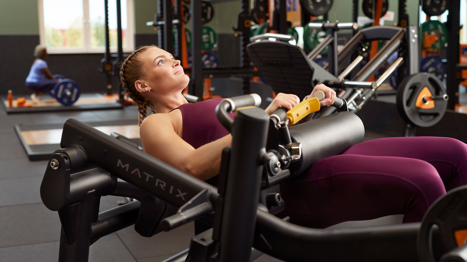Femme utilisant une machine de hip thrust en salle de sport pour cibler les fessiers